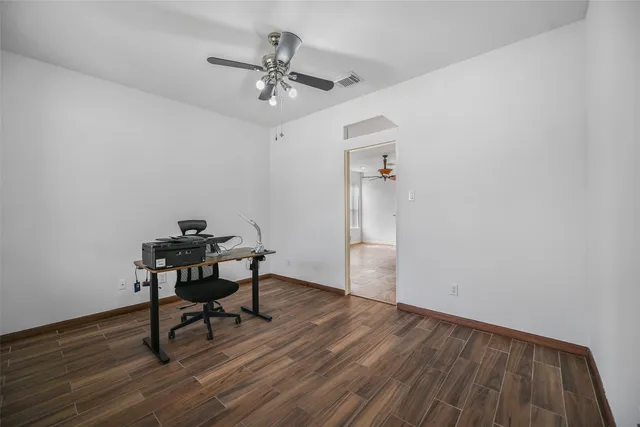 a view of a workspace with wooden floor and a window