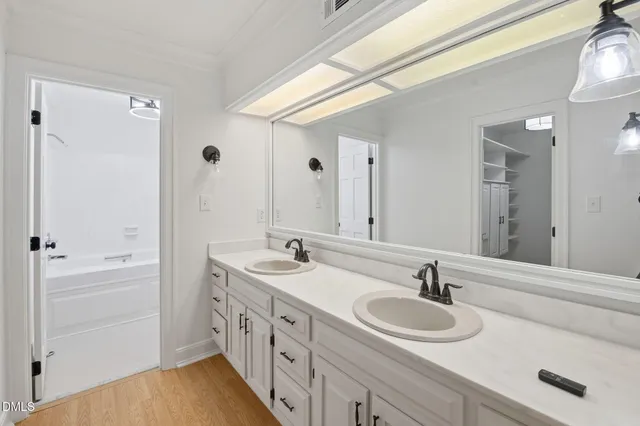 a bathroom with double vanity sinks and a mirror