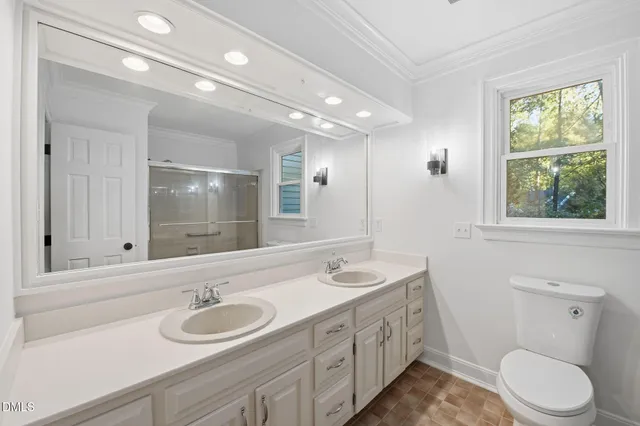 a bathroom with a double vanity sink toilet and a mirror