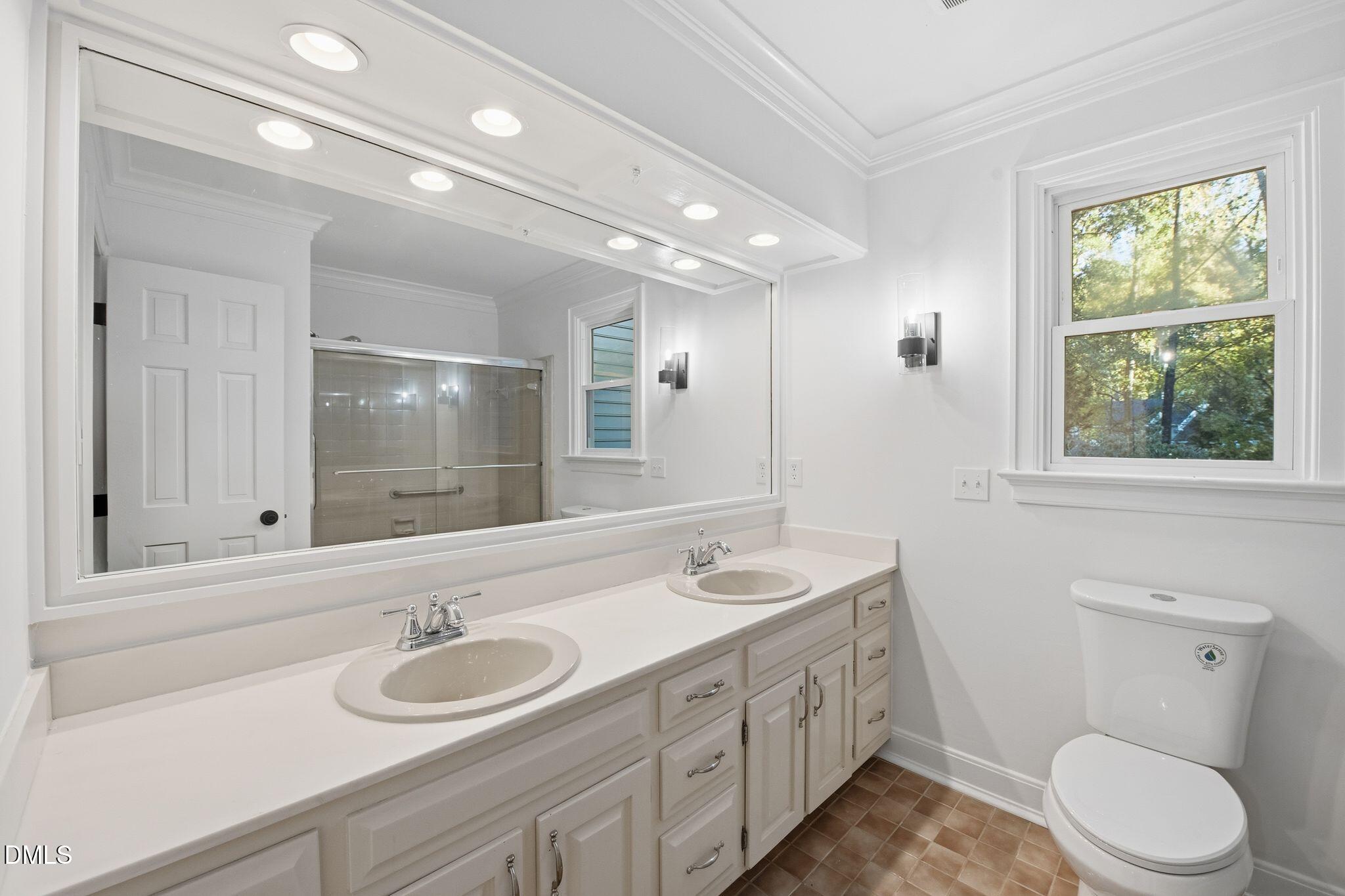 2205 Landings Way Raleigh, NC 27615 - Photo 26 of 35 a bathroom with a double vanity sink toilet and a mirror