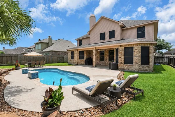 a view of a house with swimming pool and sitting area