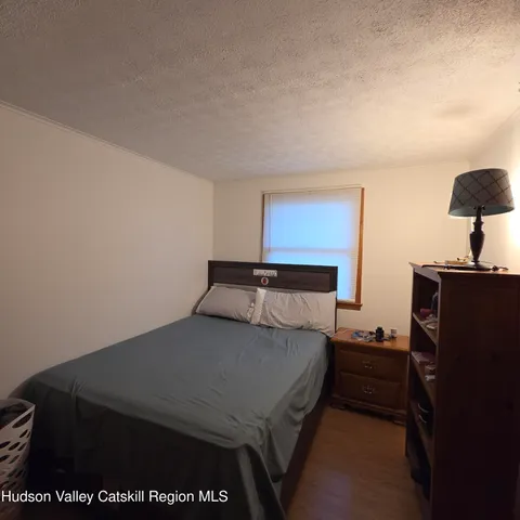 a bedroom with a bed and a lamp on the dresser