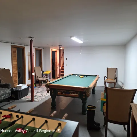 a room with furniture pool table and flat screen tv