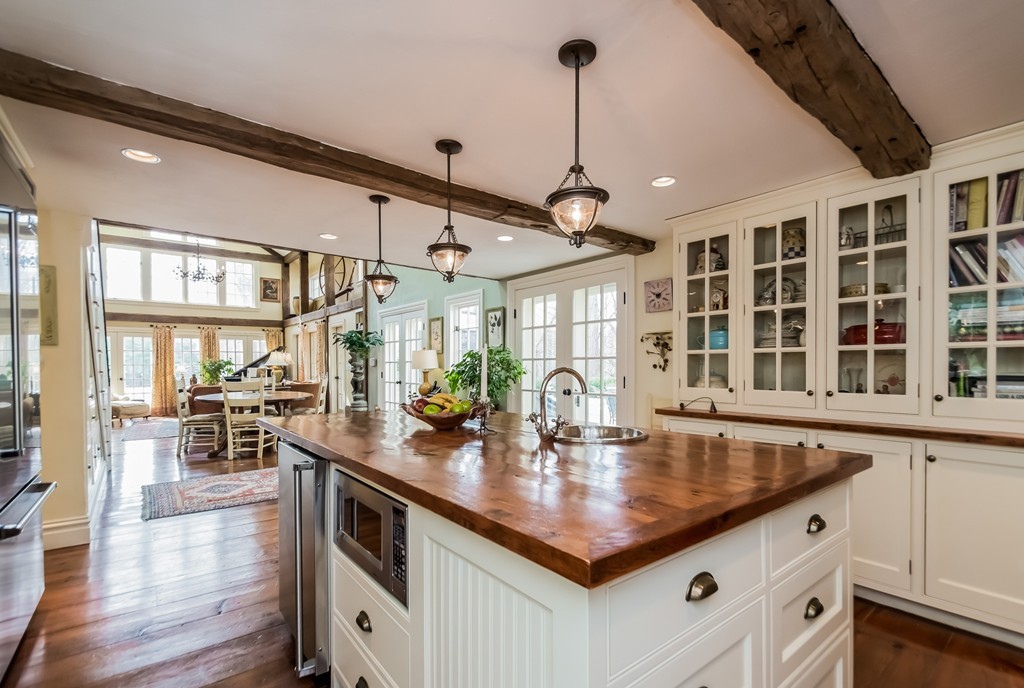 489 Bay Road Hamilton, MA 01982 - Photo 11 of 30 a kitchen with stainless steel appliances granite countertop a sink counter space dining table and chairs