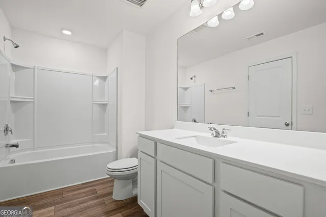 a bathroom with a sink a toilet and a large mirror