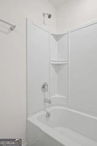 a white bath tub sitting next to a shower