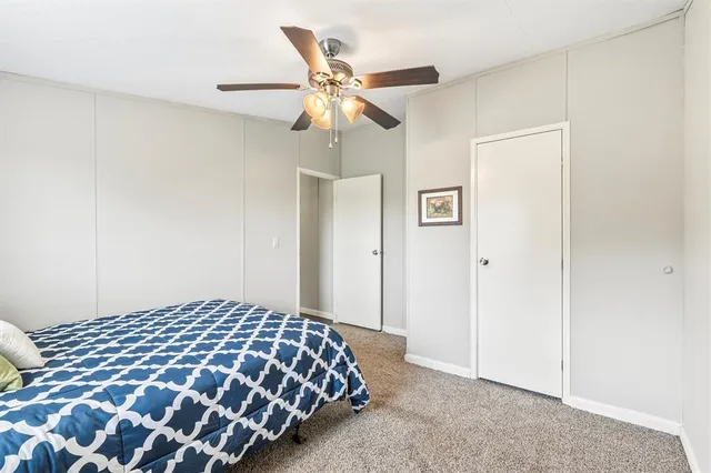a bedroom with a bed and a ceiling fan