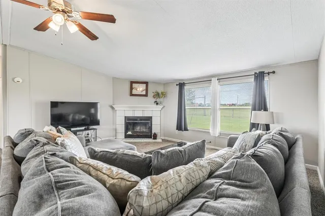 a living room with furniture a large window and a flat screen tv