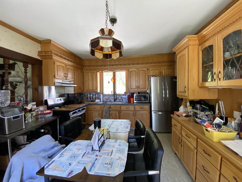 109 Brookfield Road Brimfield, MA 01010 - Photo 10 of 19 a kitchen with stainless steel appliances kitchen island granite countertop a stove a sink a dining table and chairs with wooden floor
