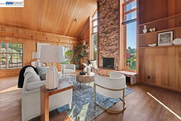 a living room with fireplace furniture and a large window