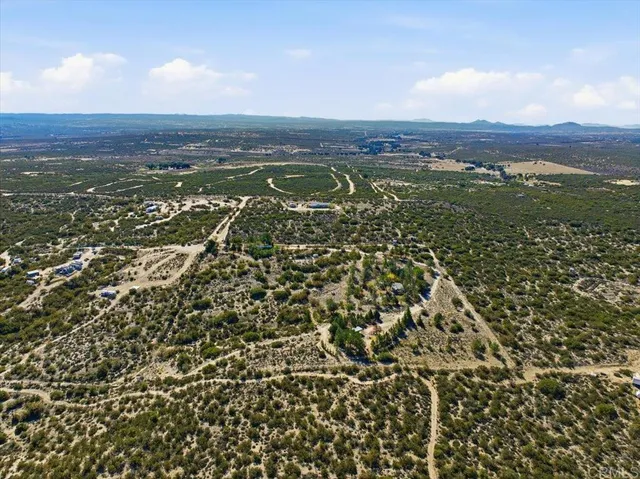an aerial view of residential houses with outdoor space and trees