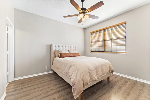 a bedroom with a bed and a ceiling fan