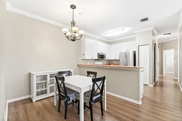 a view of a dining room with furniture wooden floor and chandelier