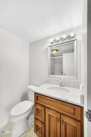 a bathroom with a granite countertop toilet sink and mirror
