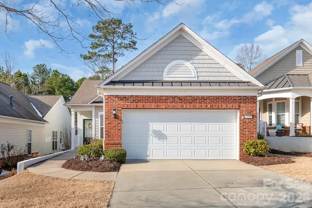 a view of house with garage and outdoor seating
