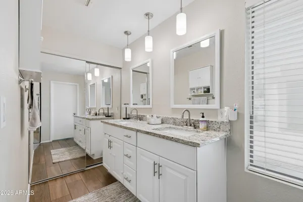 a spacious bathroom with a double vanity sink a mirror and a shower