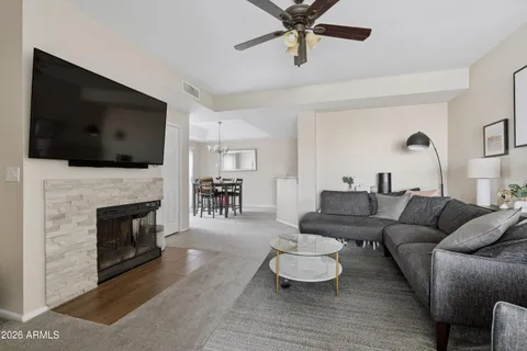 a living room with furniture a flat screen tv and a fireplace