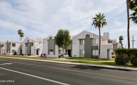 a view of a white house with a yard and potted plants