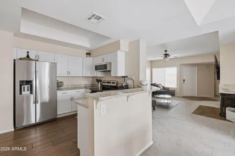 a kitchen with a refrigerator a stove top oven a sink dishwasher and wooden cabinets