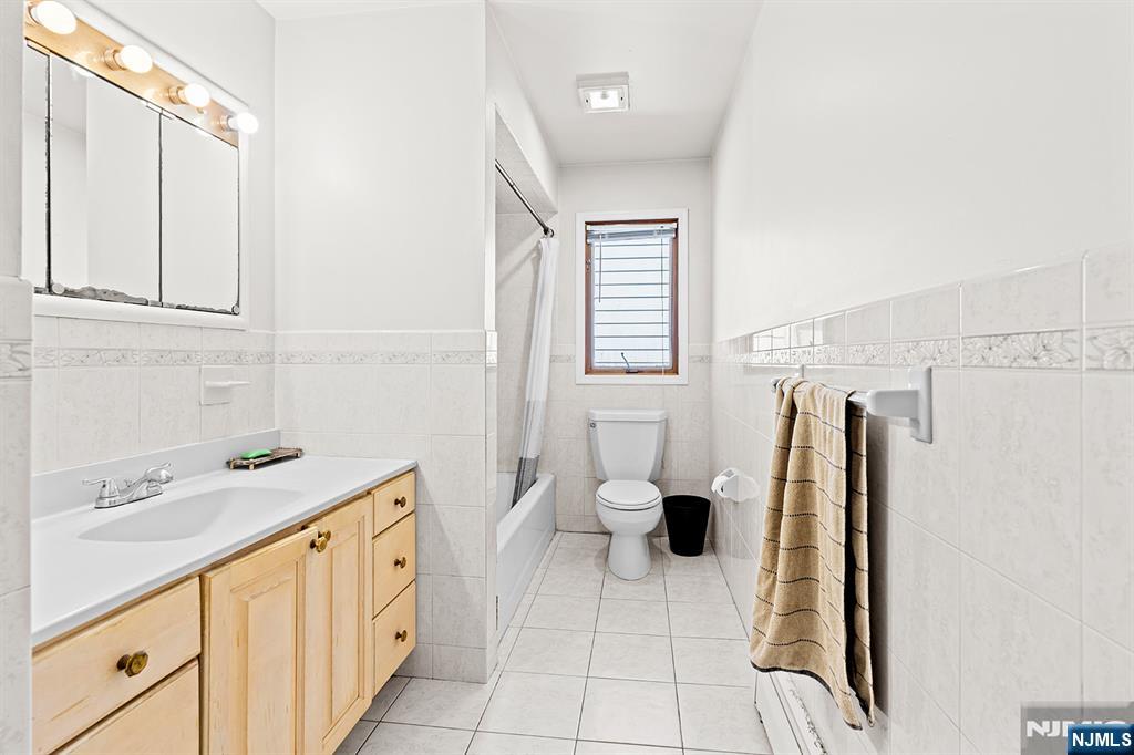 19 Cherry Street Garfield, NJ 07026 - Photo 11 of 43 a bathroom with a sink a toilet and a shower