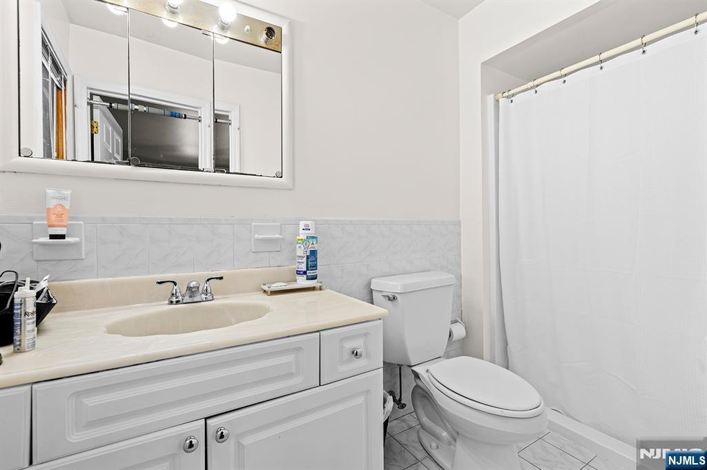 19 Cherry Street Garfield, NJ 07026 - Photo 13 of 43 a bathroom with a sink toilet and shower