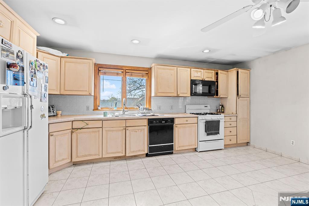 19 Cherry Street Garfield, NJ 07026 - Photo 15 of 43 a kitchen with white cabinets a sink and white appliances