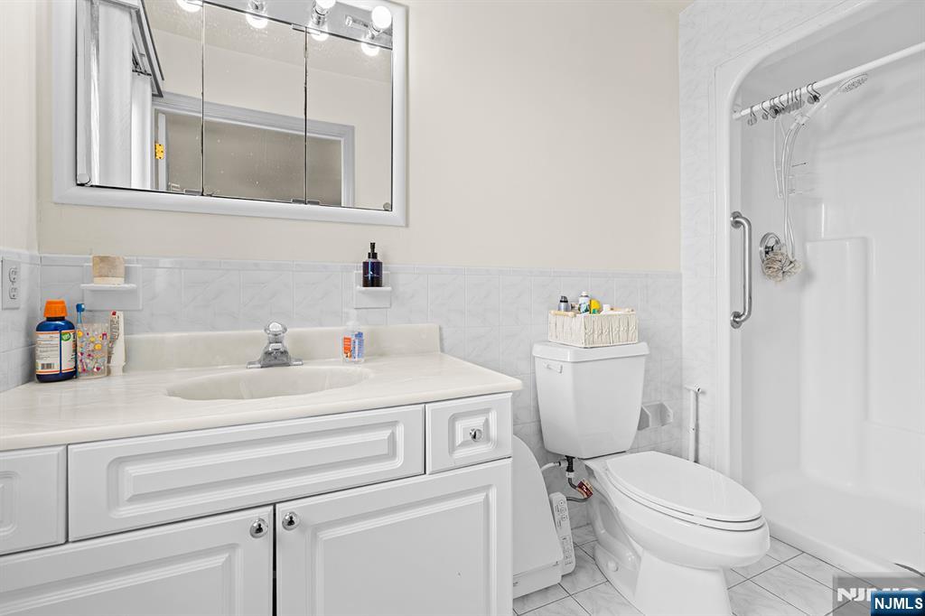 19 Cherry Street Garfield, NJ 07026 - Photo 29 of 43 a bathroom with a sink toilet vanity and shower