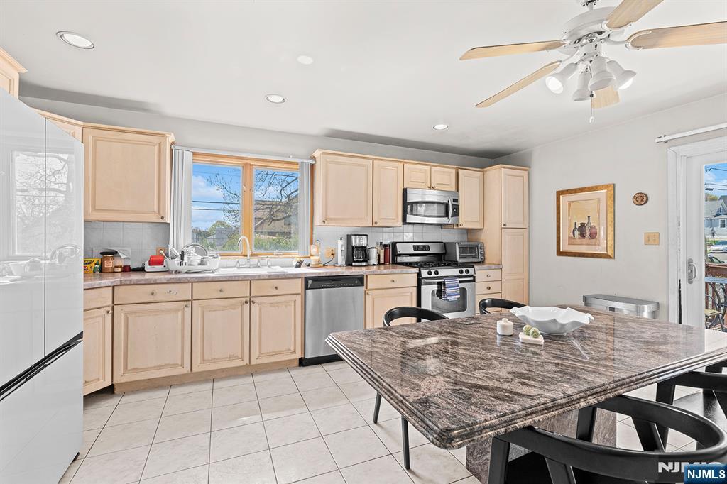 19 Cherry Street Garfield, NJ 07026 - Photo 31 of 43 a kitchen with granite countertop a stove a sink a dining table and chairs
