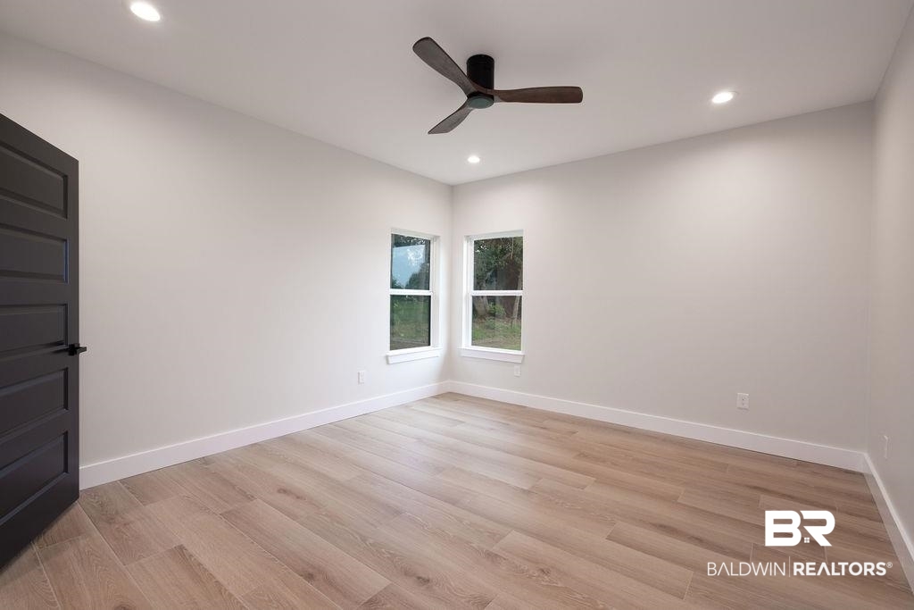 13066 Gopher Court Elberta, AL 36530 - Photo 19 of 38 Spacious room featuring wood-finish flooring, a modern ceiling fan, recessed lighting, and two windows with white trim