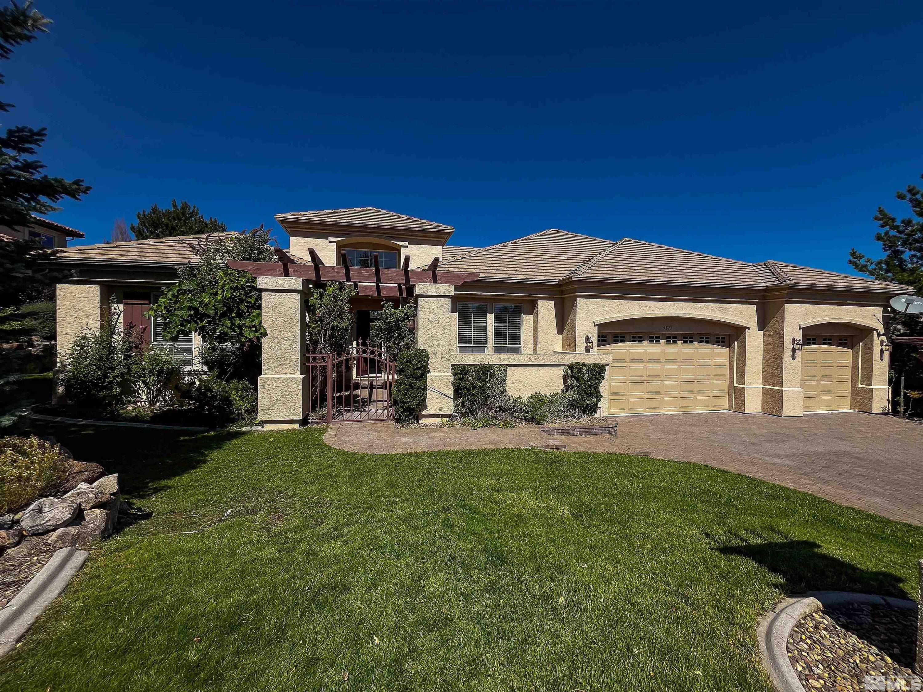 4875 Mountainshyre Road Reno, NV 89519 - Photo 1 of 13 a front view of a house with a yard table and chairs