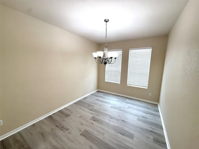 a view of empty room with wooden floor and ceiling fan