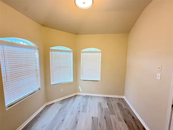 a view of room with window and wooden floor