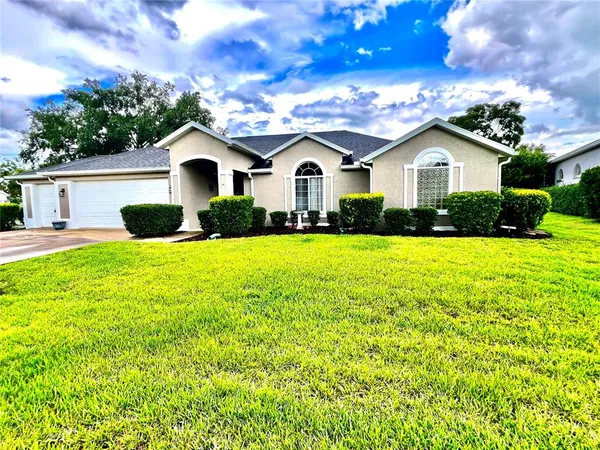 a front view of a house with yard and garage