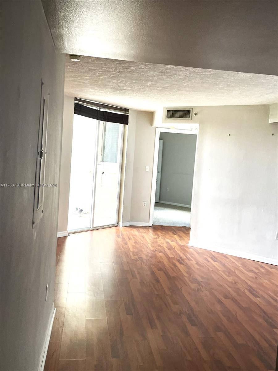 102 Southwest 6th Avenue, Unit 501 Miami, FL 33130 - Photo 15 of 18 an empty room with wooden floor and windows