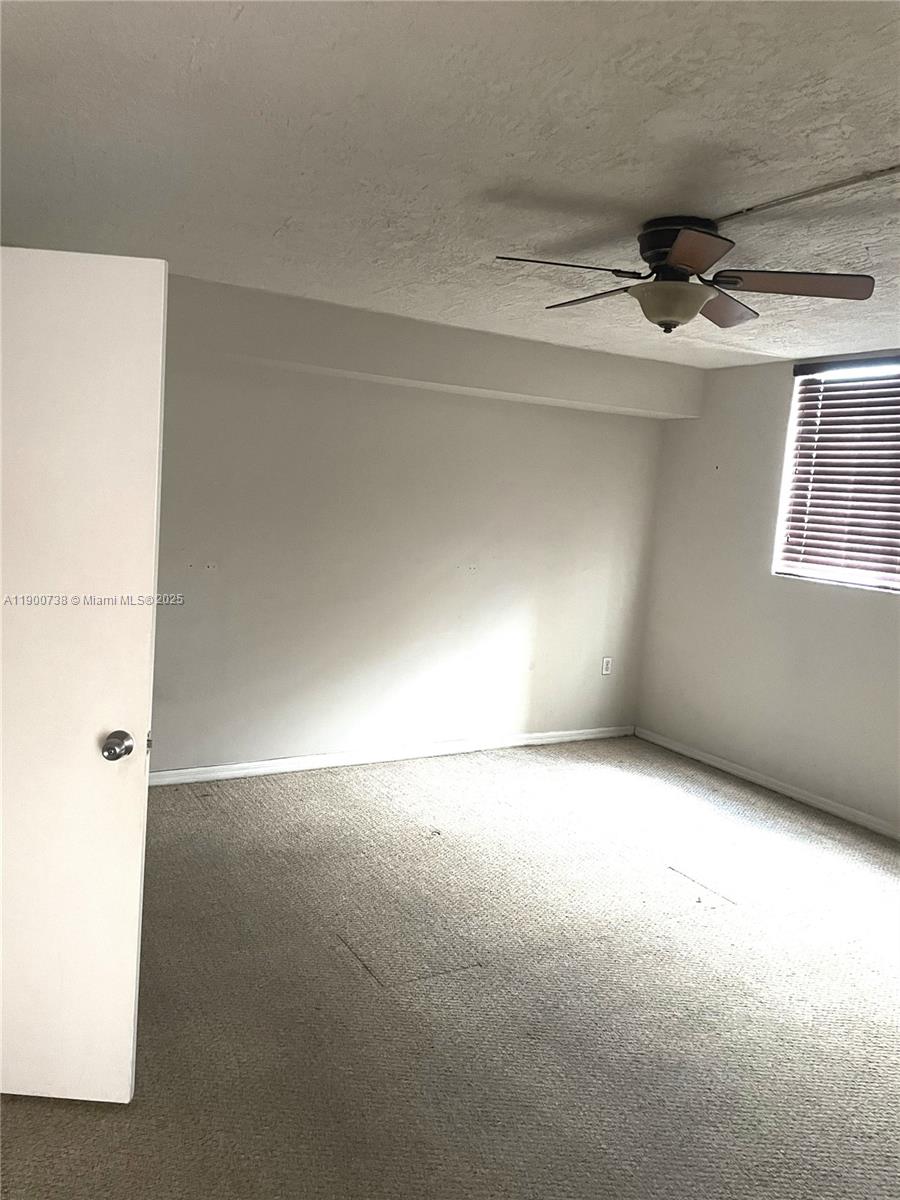 102 Southwest 6th Avenue, Unit 501 Miami, FL 33130 - Photo 2 of 18 an empty room with windows and ceiling fan