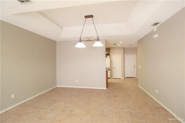 a view of a room with a ceiling fan and entryway