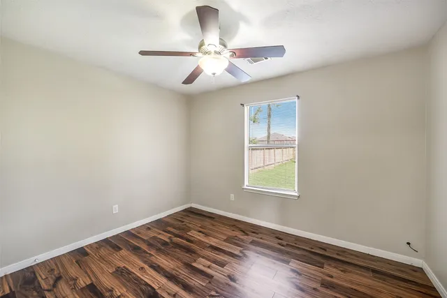 wooden floor in an empty room with a window