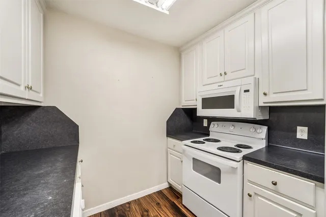 a kitchen with appliances a sink and cabinets
