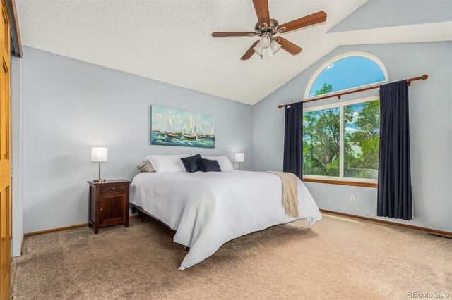 a spacious bedroom with a large bed and a chandelier