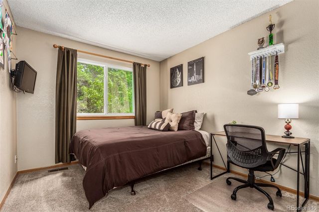 a bedroom with a bed a chair and a large window