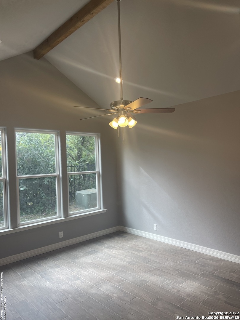 107 Sutton Place Uvalde, TX 78801 - Photo 7 of 11 en empty room with windows and chandelier fan