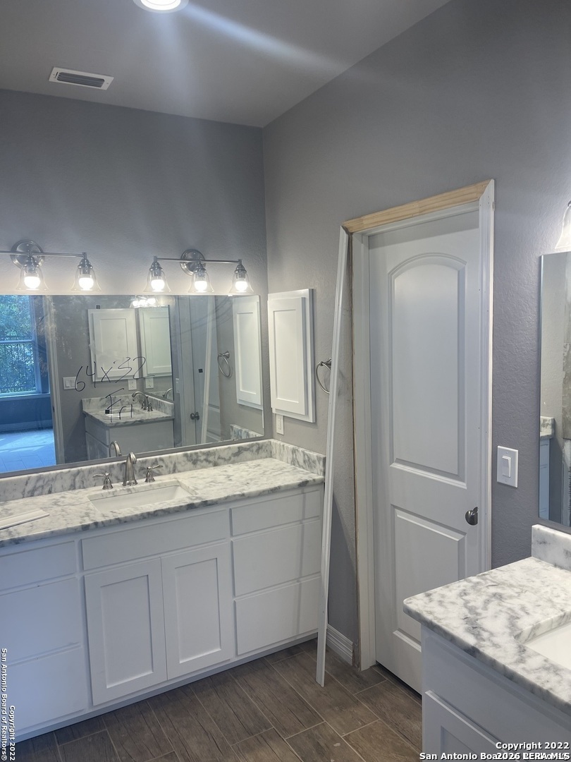 107 Sutton Place Uvalde, TX 78801 - Photo 8 of 11 a bathroom with a granite countertop sink and a mirror