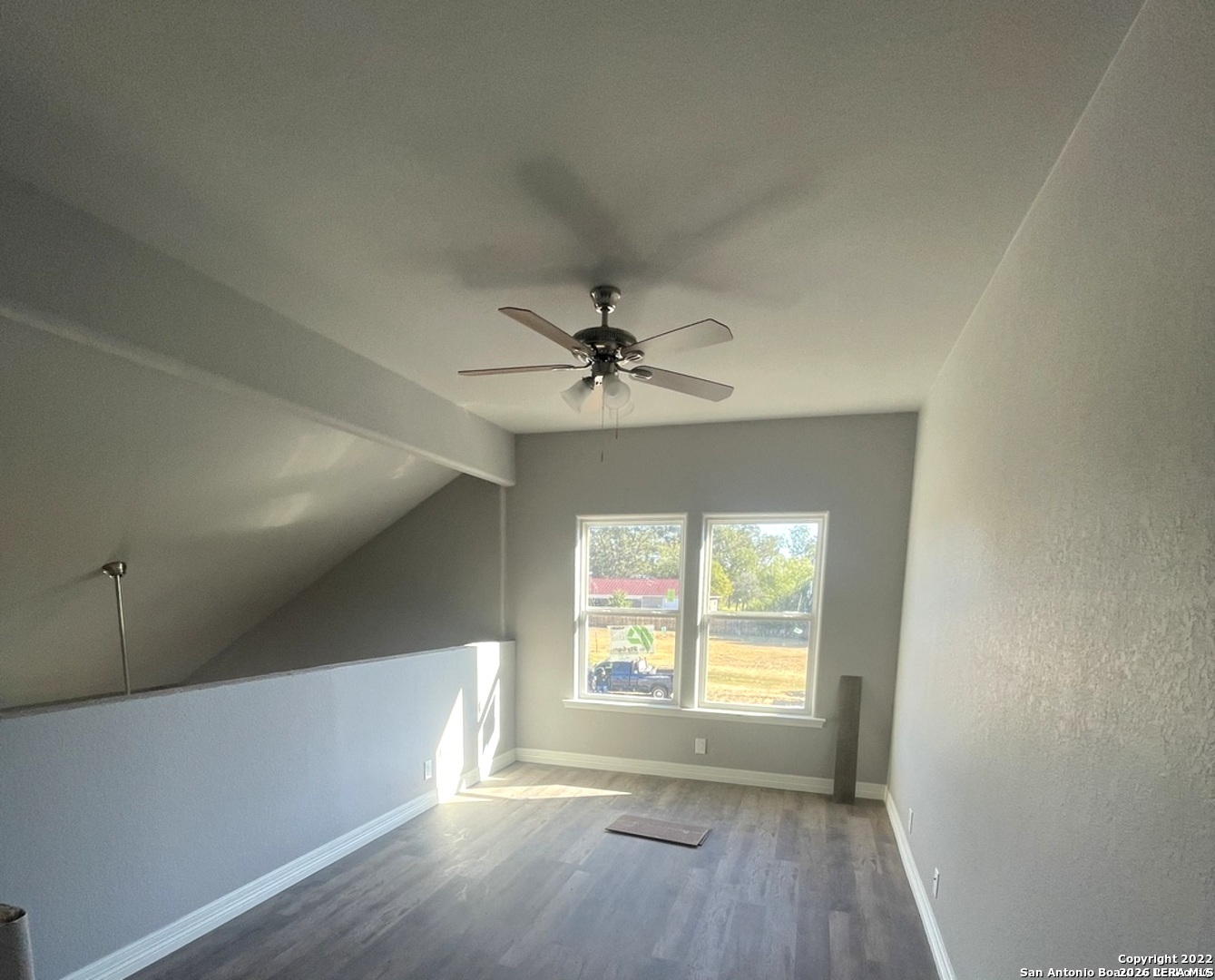 107 Sutton Place Uvalde, TX 78801 - Photo 9 of 11 wooden floor in an empty room with a window