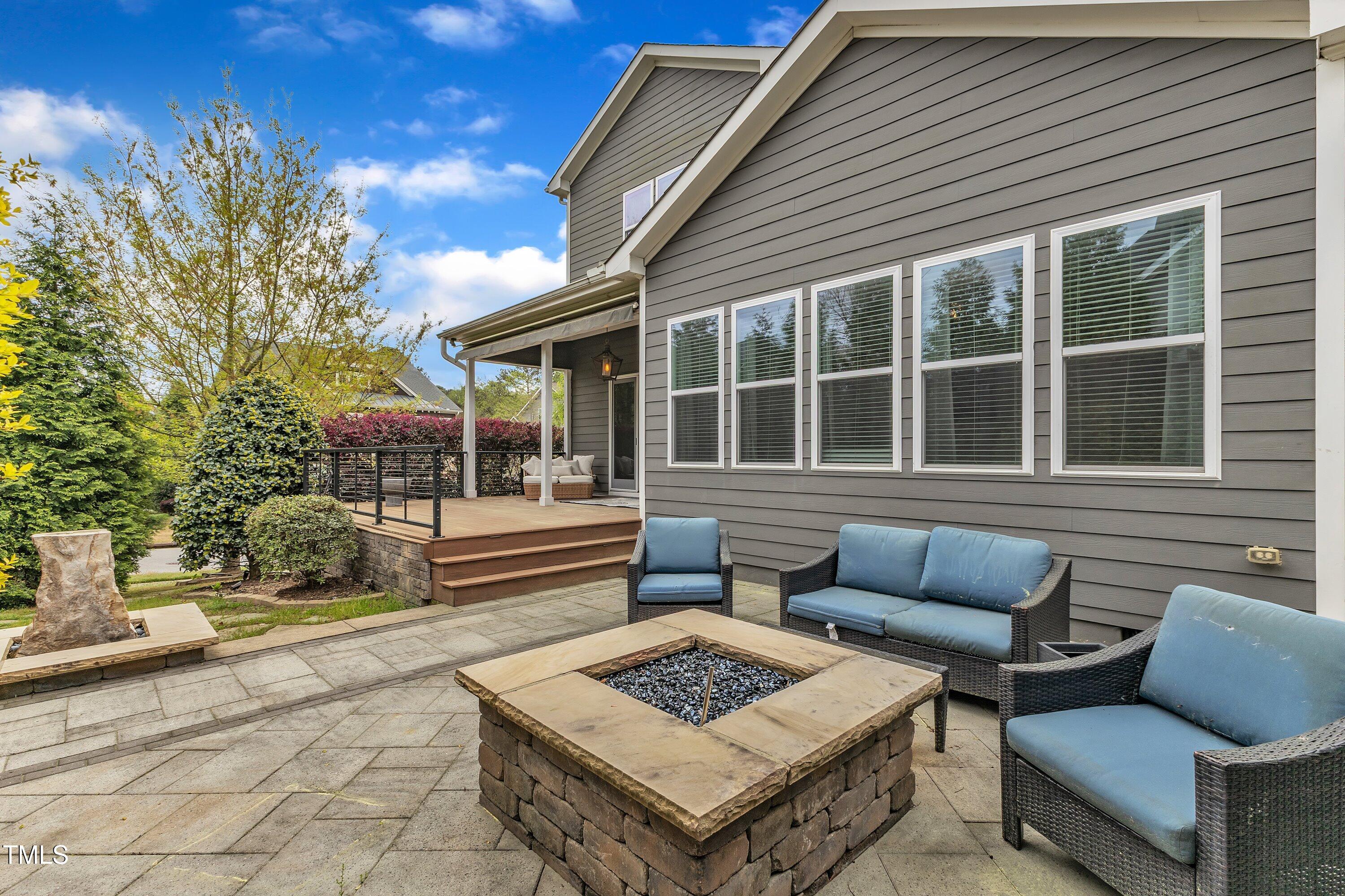 8121 Greys Landing Way Raleigh, NC 27615 - Photo 67 of 95 a view of a patio with couches and a table and chairs with wooden floor and fence