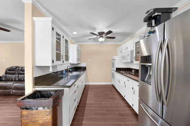 a kitchen with stainless steel appliances granite countertop a stove a sink and a refrigerator