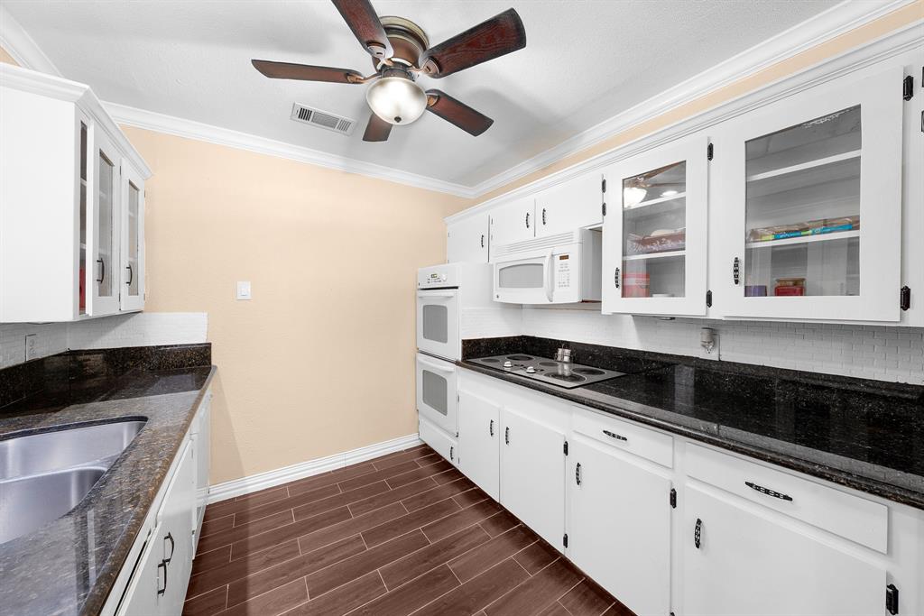 1075 Oak Ridge Drive Terrell, TX 75160 - Photo 12 of 28 a kitchen with granite countertop a sink and cabinets