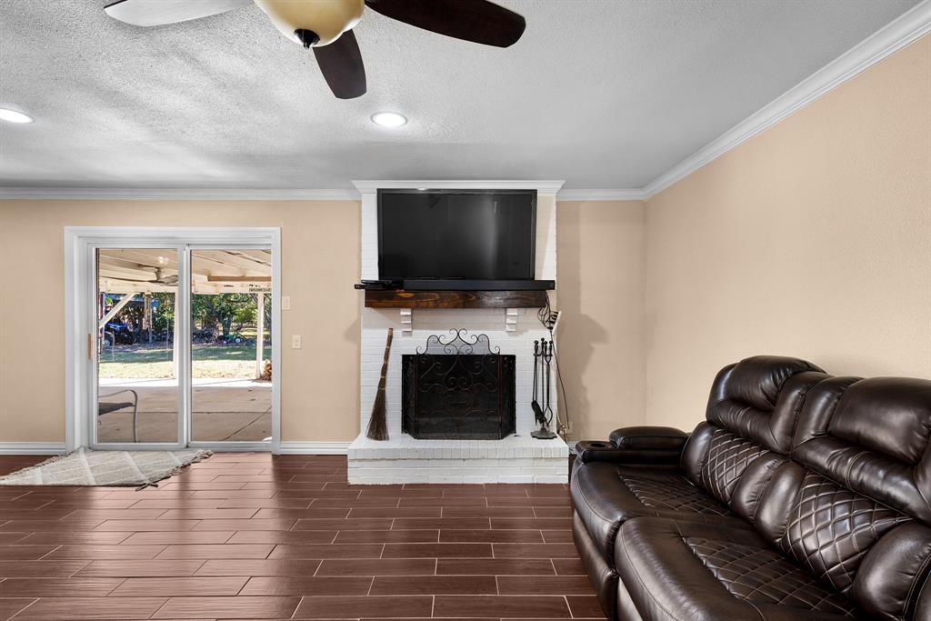 1075 Oak Ridge Drive Terrell, TX 75160 - Photo 18 of 28 a living room with furniture flat screen tv and a fireplace