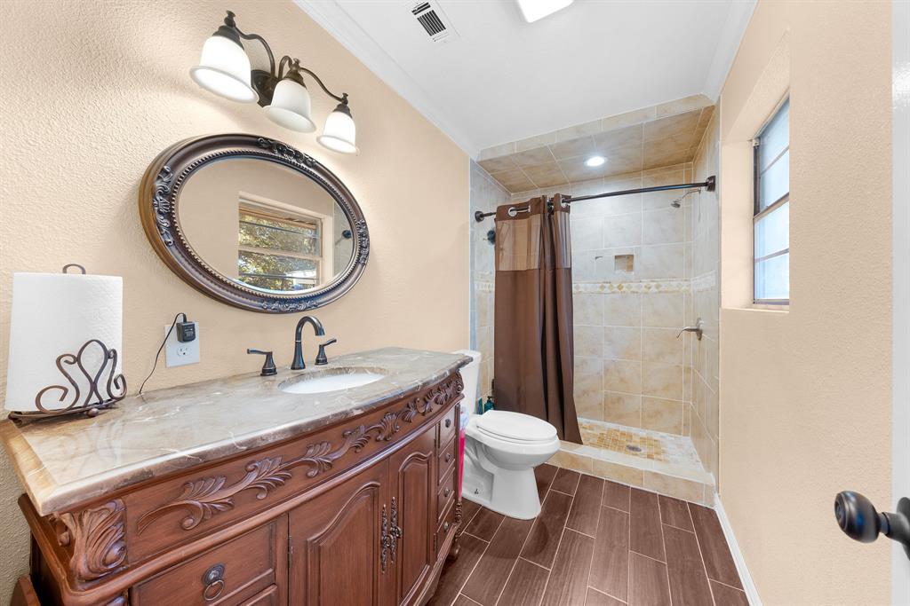1075 Oak Ridge Drive Terrell, TX 75160 - Photo 25 of 28 a bathroom with a sink a toilet and a mirror