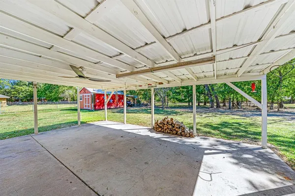 a view of a backyard with plants and porch with a table