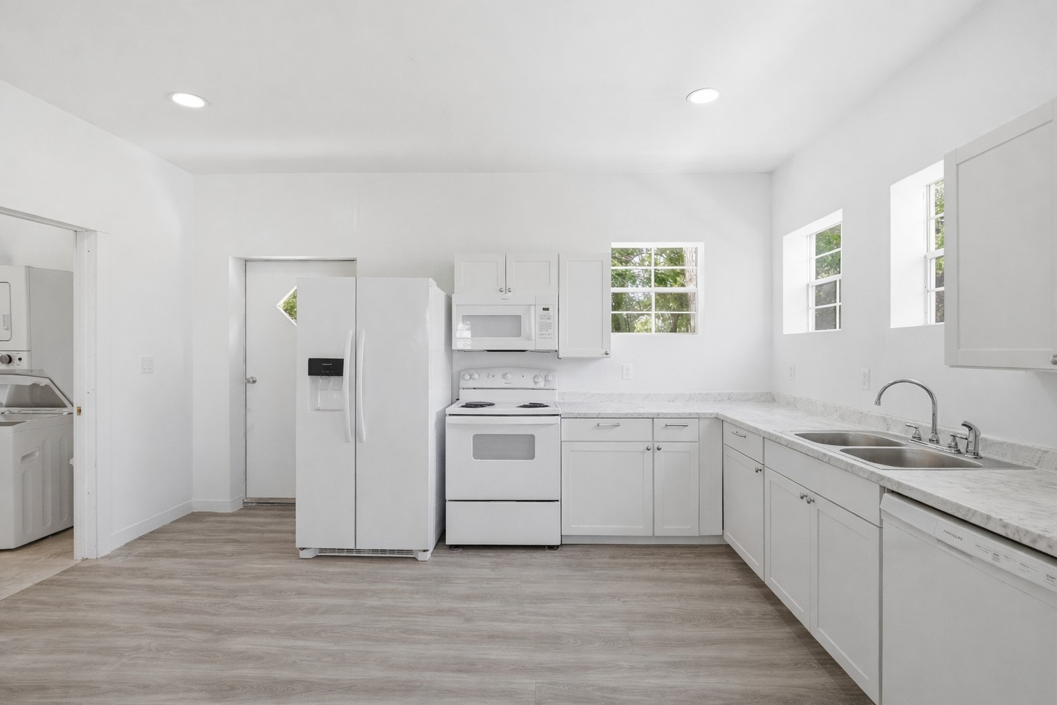 224 Old Coach Lane Elgin, TX 78621 - Photo 8 of 25 Bright kitchen featuring white cabinetry, light countertops, and white appliances including a refrigerator, range, microwave, and dishwasher